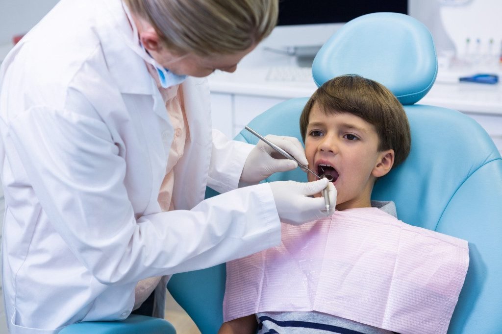 boy receiving dental treatment by dentist 1 Mason Dentistry New Home